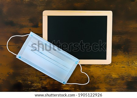 blackboard and one facemask on wooden background. illustration painting background