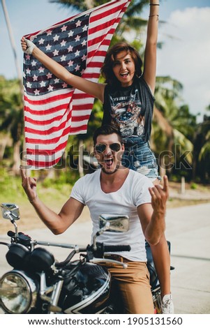 young couple in love, riding a motorcycle, hug, passion, free spirit, vintage, hipster, romantic, tropic vacation, honey moon, american usa flag on independance day