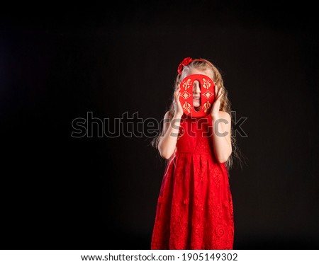 O holds a child holding in his hand the letter LOVE Valentine symbol, board, on the floor hearts of married space. holiday formula. copy of the space formula of love, joy in red girl dress, barefoot