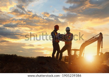 Construction engineers supervising progress of construction project ,Engineering Consulting People on construction site holding blueprint in his hand.  Royalty-Free Stock Photo #1905239386