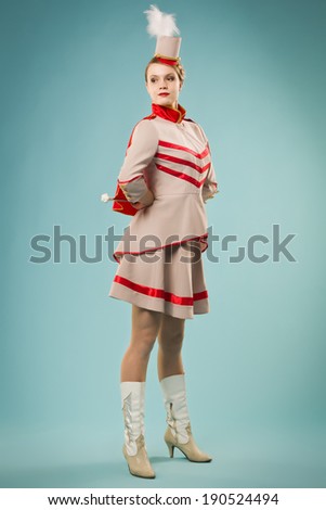 Pretty girl in uniform majorettes posing with stick