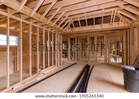 Wooden under construction new residential home beam framing and PVC plastic drain pipe Royalty-Free Stock Photo #1905261340