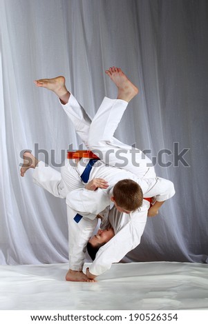 Sportsmen with a blue and orange belt are doing judo throws Royalty-Free Stock Photo #190526354