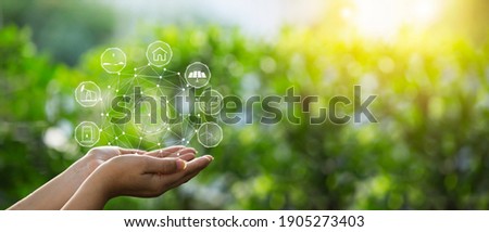 Technology, hand holding with environment Icons over the Network connection on green background. Royalty-Free Stock Photo #1905273403