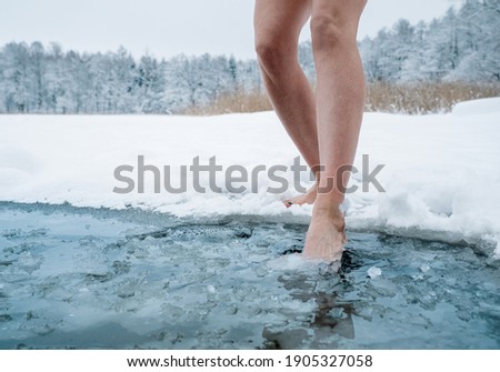 Close up of female legs getting into ice cold water Royalty-Free Stock Photo #1905327058