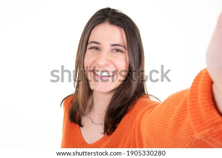 smiling woman make selfie by camera over isolated white background with a big smile on face