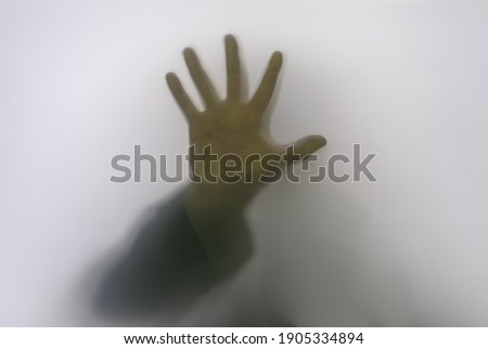 Shadow silhouette of person in glass, people behind mirror