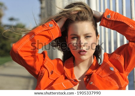 Very beautiful young girl portrait with long blond hair with an orange jacket enjoys the nature of Turkey
