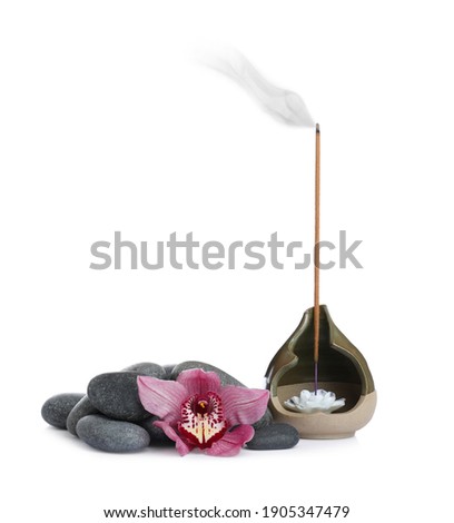 Incense stick smoldering in holder near orchid flower and spa stones on white background Royalty-Free Stock Photo #1905347479