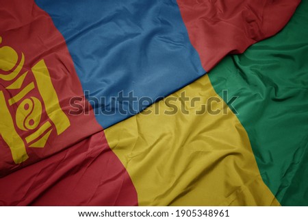 waving colorful flag of guinea and national flag of mongolia. macro