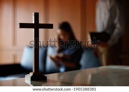 Close up cross is blur background. Asian Christian woman and man holding hands in praying for Jesus' blessings to show love and confession of their sins according. Concept giving love faith