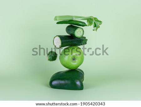 Fresh green vegetables and fruits on green background. Equilibrium floating food balance in monochrome. Alcaline diet, smoothie concept. Royalty-Free Stock Photo #1905420343