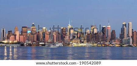 Hudson River waterfront view of New York City Manhattan after sunset with cityscape panorama and light reflection in tranquil blue tone.