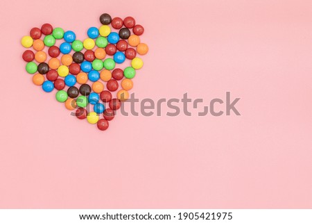 top view heart of Colorful chocolate coated candy on pink background with valentines. Valentines day concept festive food gifts