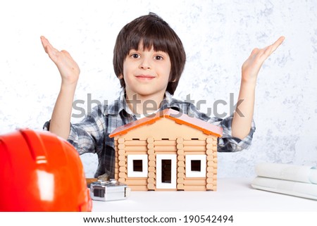 boy built a new house and shows his hands up