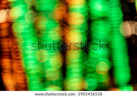 Orange and green lights presented in an out of focus bokeh effect for a happy and festive background.