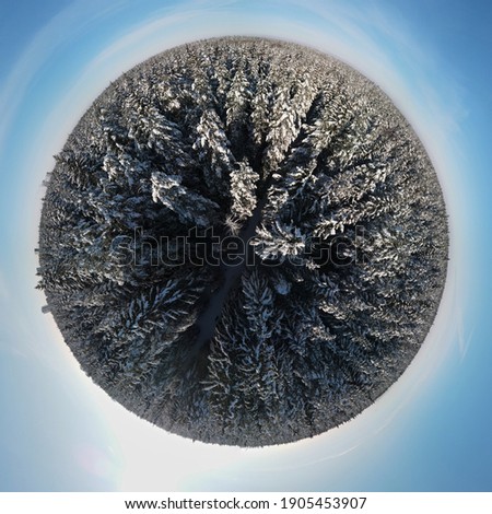 photo from a flying drone, a small planet and a winter landscape, the forest is covered with snow