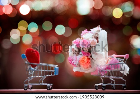 Shopping cart with a red hearts and  Bouquet of roses  on multicolored bokeh light background, Happy valentines day