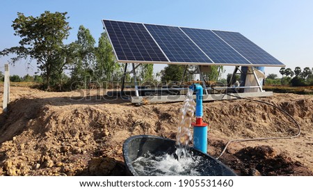Water pumps and solar panels. Groundwater is pumped with a submersible pump from clean energy or solar energy converted to electric energy on an agricultural farm with a copy area. Selective focus Royalty-Free Stock Photo #1905531460