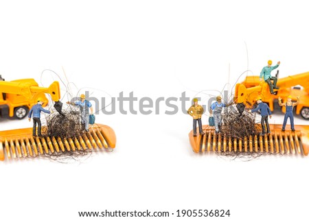 miniature workers with hair on wooden comb, image for solution hair loss concept.