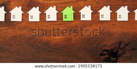 many small white houses one red and one green on a wooden board 