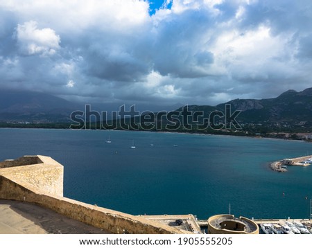 Aerial view of the port of Calvi with dramatic sky. Corsica, France. Tourism and vacations concept.