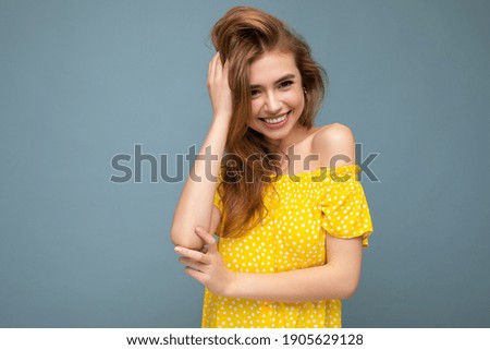 Photo shot of pretty joyful smiling young female person wearing casual trendy outfit standing isolated on colourful background with copy space looking at camera and having fun