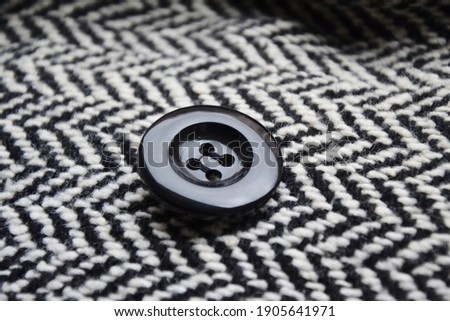 Round button on a black and white fabric with chevron pattern
