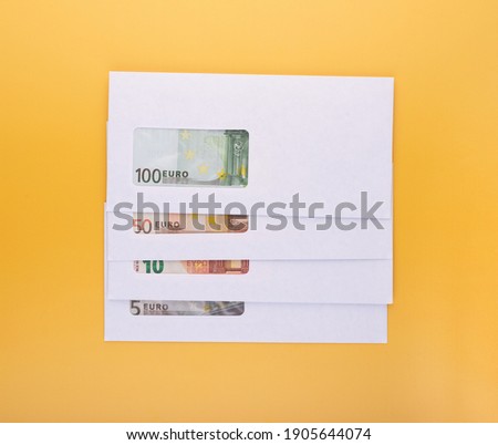 Stack of closed white envelopes with euro bills inside on yellow background. Concept of income, bonuses or bribes. Corruption in business, illegal black salary