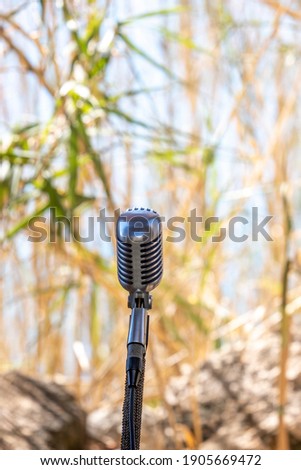 Microphone standing for speaker on the outdoor natural setting for music, concert and environmental awareness talk with copy space stock photo