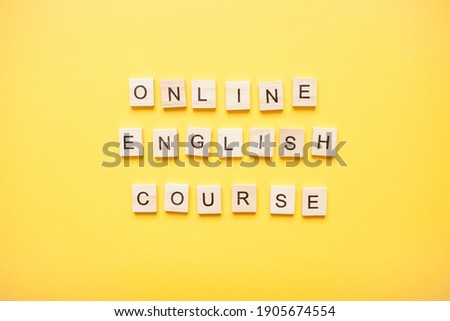 Phrase online english course made from wooden blocks on a light yellow background