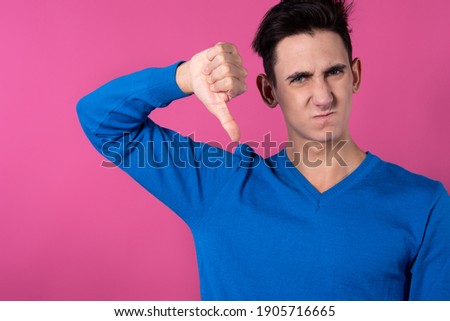 A young man gestures with his hands. Pink background. Consent and denial. Good and bad.