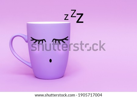 Sleeping purple coffee cup against purple background. Sweet dreams and good night, weekend concept. Minimalism style, front view, copy space.