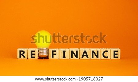 Refinance symbol. Wooden cubes with word 'refinance'. Yellow light bulb. Beautiful orange background. Business and refinance concept. Copy space. Royalty-Free Stock Photo #1905718027