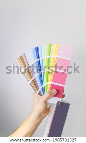 palette of paints for repair in the hands of a male isolate. Selective focus. People.