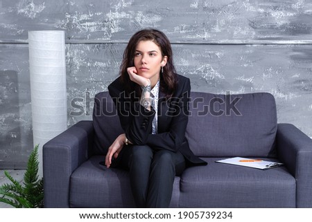 boring businesswoman in a black suit sitting in the office