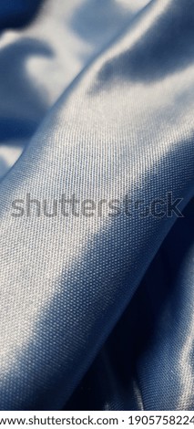 Beautiful blue polyester. Delicate smooth fabric. Blue background.