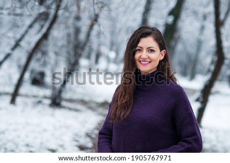 Positive woman posing for a photo. Girl appreciating cold weather. Winter concept.