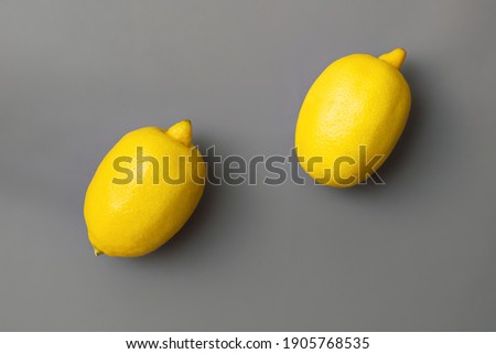 Yellow lemons on gray background. Colors of the Year 2021 Illuminating and Ultimate gray, flat lay, copy space