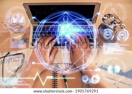 Double exposure of man's hands typing over computer keyboard and science theme hologram drawing. Top view. Education concept.