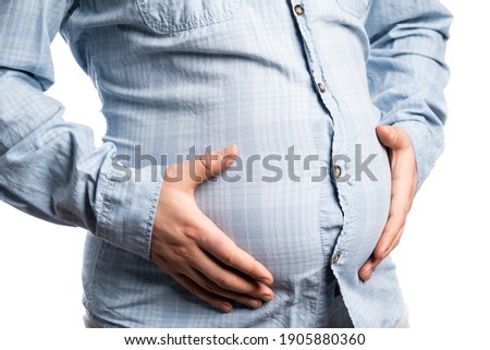 Men's hands clasp a bulging plump belly Royalty-Free Stock Photo #1905880360