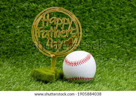 Baseball with Happy Father's Day sign on green grass