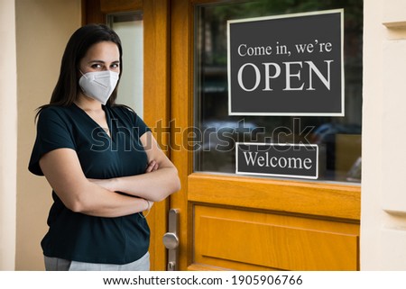 Business Owner At Store Entrance Holding Open Sign