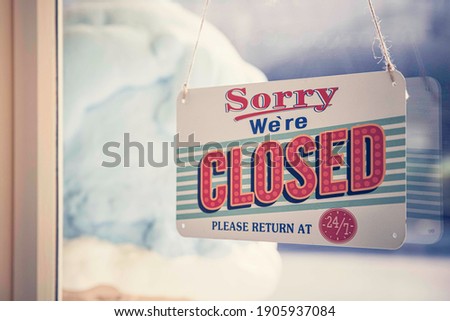 Closed sign hanging on the front door of the store