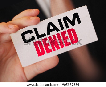 Businessman shows a card with text Claim Denied . Injury claim insurance concept.