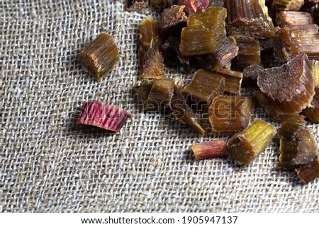 Dried rhubarb candied fruits. Candied rhubarb on a canvas fabric background. Dry rhubarb close - up macro photography. Rheum.