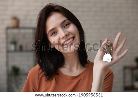 Head shot portrait smiling woman tenant showing keys to new apartment, looking at camera, happy female customer excited by purchasing new house, moving to first dwelling, mortgage or rent concept Royalty-Free Stock Photo #1905958531
