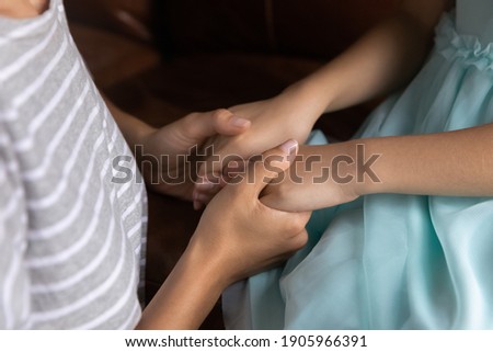 Close up caring mother holding little daughter child hands, expressing love and care, mum comforting, supporting kid, children protection, psychological help concept, family enjoying tender moment Royalty-Free Stock Photo #1905966391