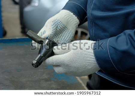 In the hands of a car mechanic steering tip, close-up. Inspection of the steering and suspension parts before installing them during the repair and maintenance of the passenger car in the service cent