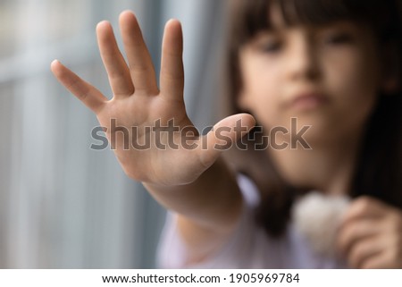 Close up lonely little girl offering stretching hand at camera, asking help, domestic violence victim, upset preschool child kid waiting for parents, adoption and children custody concept Royalty-Free Stock Photo #1905969784
